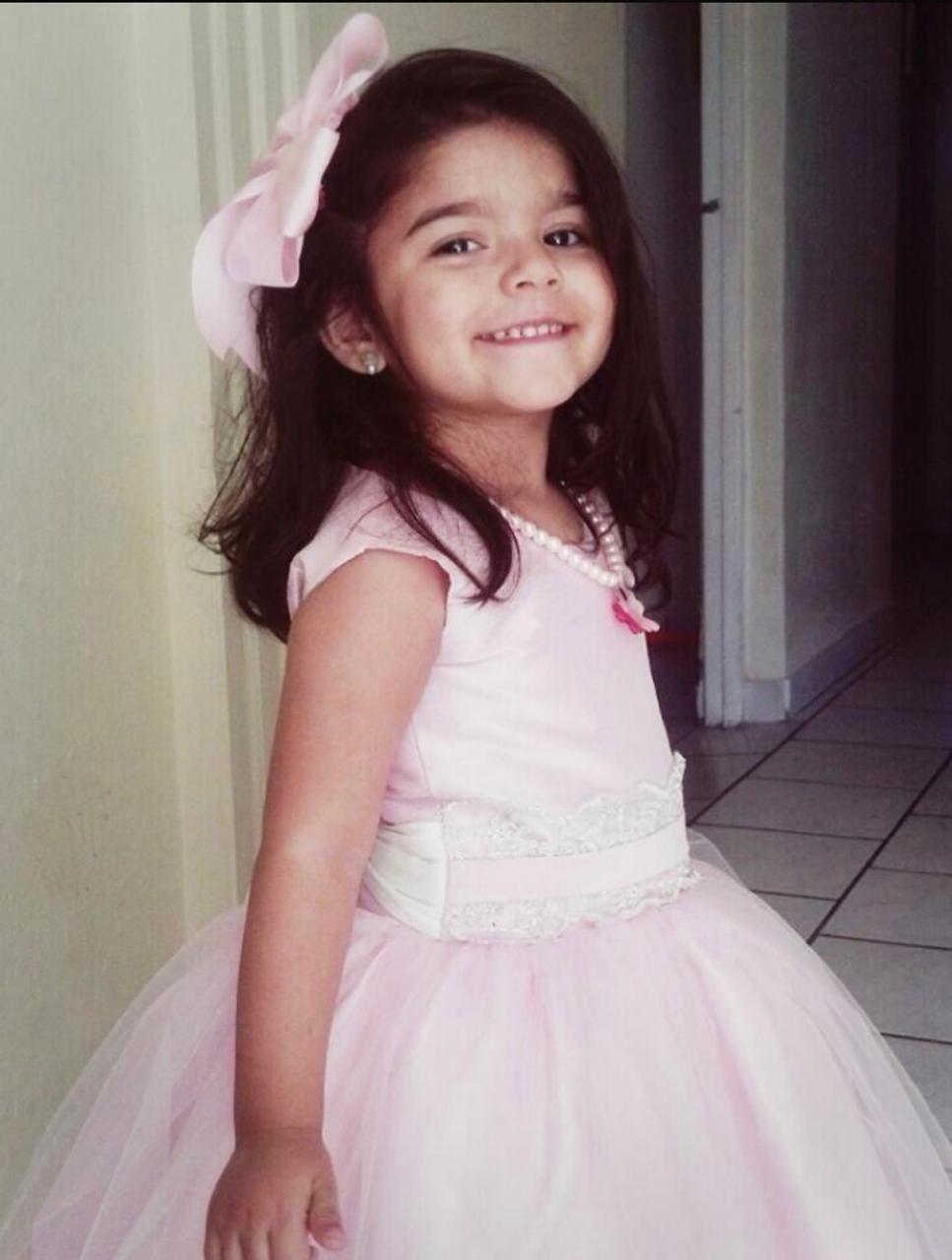 Sofía de niña, con vestido rosa y moño